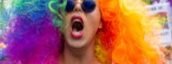 Colorful participant with rainbow wig and sunglasses at Brussels Pride Parade.