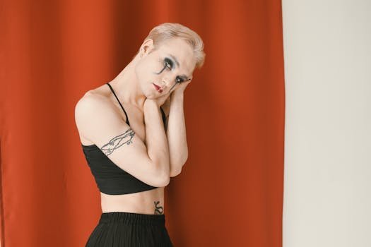 Expressive portrait highlighting dramatic makeup and an emotional pose against a red backdrop.